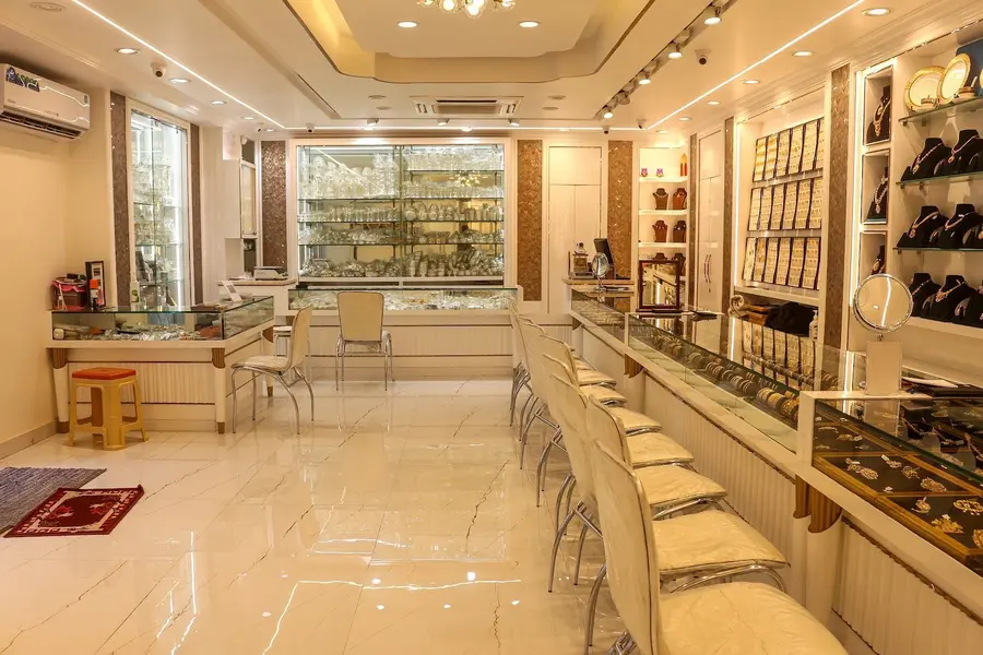 The hall: one long glass counter with rows of white chairs, warm cove lighting, walls of gold.